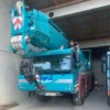 A crane is parked in the garage of an industrial building.